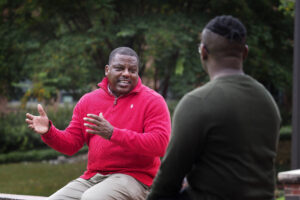 Joe Johnson, student diversity coordinator in the College of Humanities and Social Sciences, speaks with an undergrad student in the Court of North Carolina. Photo by Marc Hall